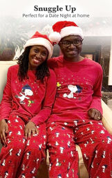 Man and Woman sitting on couch wearing matching Snoopy Pajamas with the following copy: Snuggle Up - Perfect for a Date Night at Home image number 1