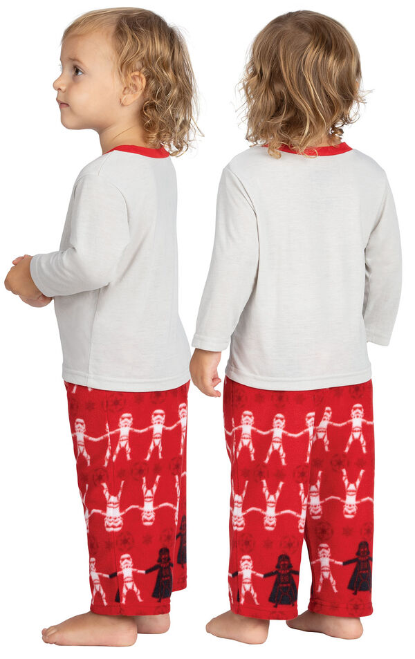 Model wearing Red Star Wars PJ for Infants, facing away from the camera and then to the side image number 1