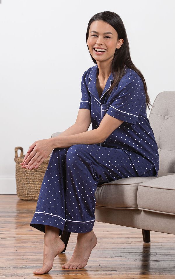 Model sitting on couch wearing Navy Blue and White Polka Dot Short Sleeve Button-Front PJ for Women