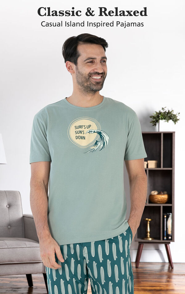 Model wearing Margaritaville Summer Breeze Men's Pajamas - Teal by couch with the following copy: Casual Island Inspired Pajamas image number 2