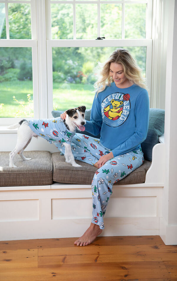 Woman and dog sitting at bay window wearing matching Grateful Dead Pajamas