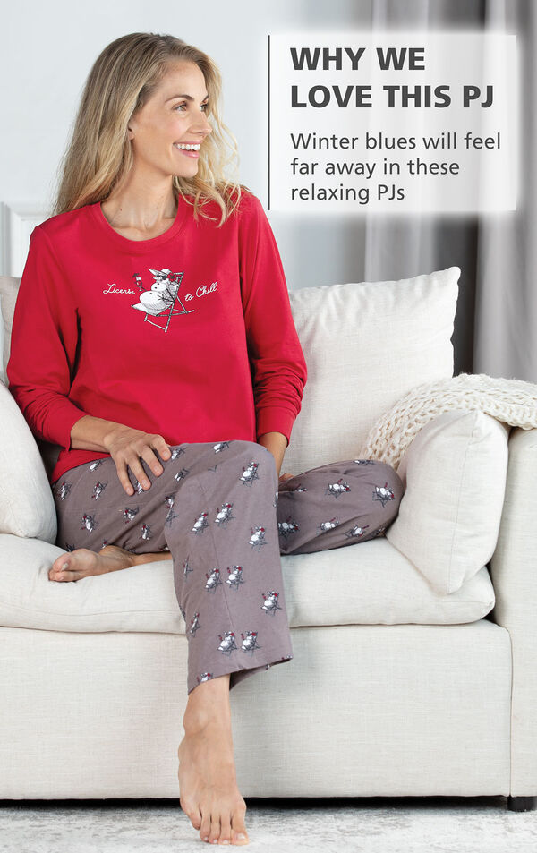Model sitting on couch wearing Margaritaville Island Time Pajamas - Sunny Snowman print with the following copy: Winter blues will feel far away in these relaxing PJs image number 2