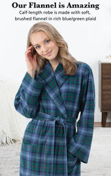 Model wearing Heritage Plaid Flannel Long Robe by bed with the following copy: Our Flannel is Amazing. Calf-length robe is made with soft, brushed flannel in rich blue/green plaid image number 2