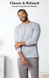 Model standing in bedroom wearing Men's Long Sleeve Striped Pajamas with the following copy: Classic and Relaxed Casual Long-Sleeve Pajamas image number 3