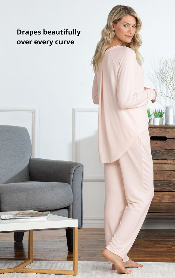 Model standing by couch wearing Pink Cloud Fine Pajamas with the following copy: Drapes beautifully over every curve image number 4