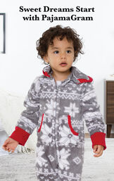 Toddler wearing Nordic Fleece Hoodie-Footie by bed with the following copy: Sweet Dreams Start with PajamaGram. image number 1