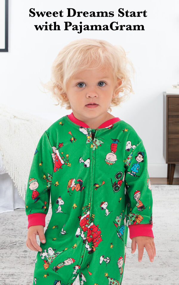 Infant wearing Charlie Brown Christmas Onesie Pajamas by bed with the following copy: Make it a Charlie Brown Christmas. image number 1