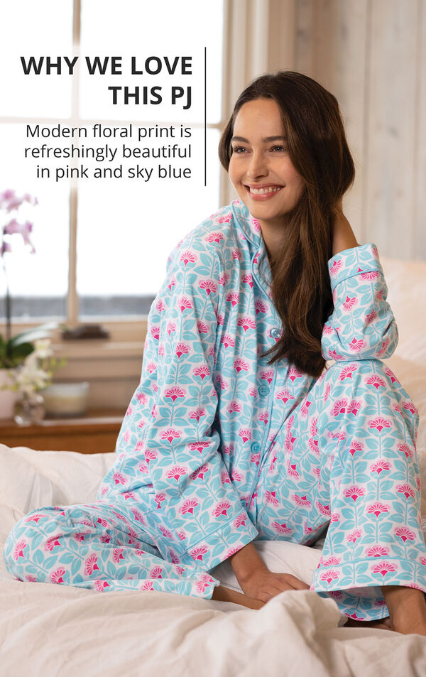 Model wearing Modern Floral Boyfriend Pajamas sitting on bed with the following copy: Modern floral print is refreshingly beautiful in pink and sky blue image number 2