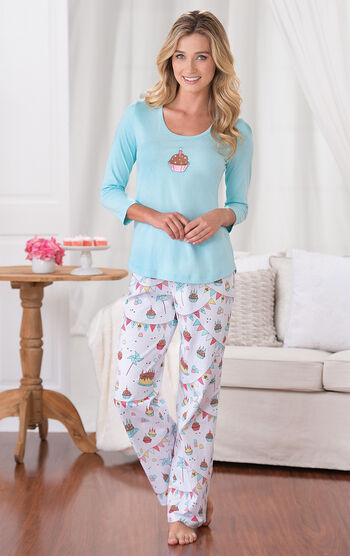 Model wearing Light Blue and White Happy Birthday Pajamas, standing by couch
