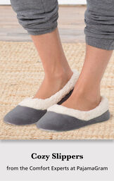Model wearing Charcoal World's Softest Slippers standing on a rug with the following copy: Cozy Slippers from the Comfort Experts at PajamaGram image number 2
