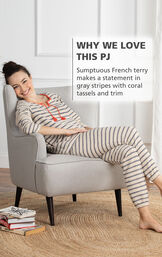 Model wearing Seeing Stripes PJs sitting on a chair with the following copy: Why We Love This PJ - Sumptuous French terry makes a statement in gray stripes with coral tassels and trim image number 2