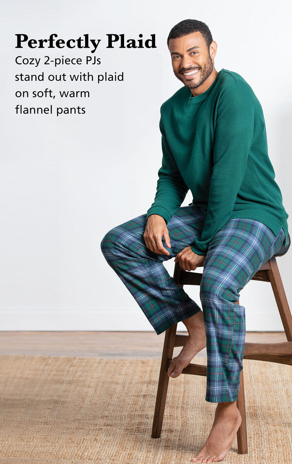 Model wearing Heritage Plaid Thermal-Top Men's Pajamas sitting on a chair with the following copy: Perfectly Plaid. 2-piece thermal PJs stand out with plaid on soft, warm flannel pants image number 2