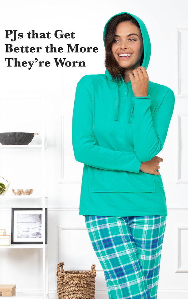 Model standing in kitchen wearing Wintergreen Plaid Hooded Women's Pajamas with the following copy: PJs that get better the more they're worn image number 2