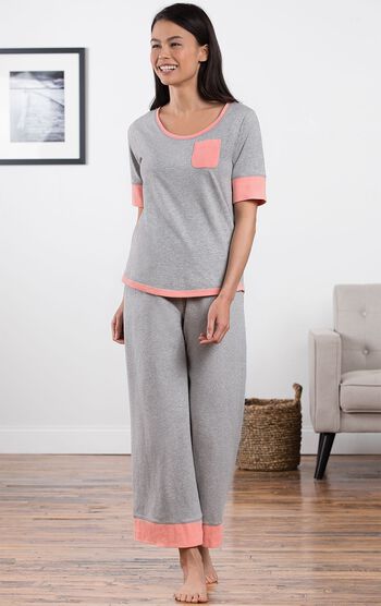Model standing in living room wearing Gray Cozy Capri Pajama Set with Coral trim and chest pocket