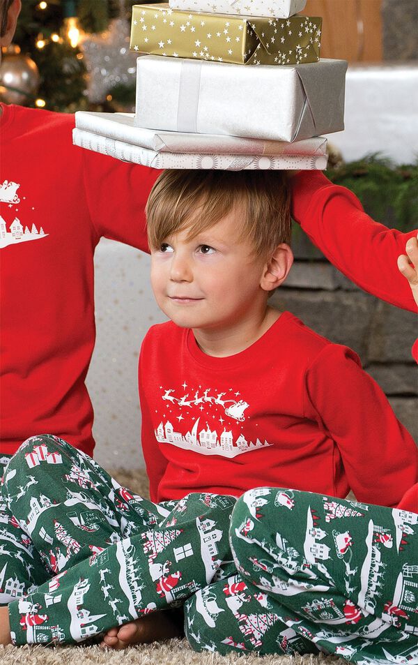 Toddler wearing The Night Before Christmas Pajamas, balancing presents on his head image number 1