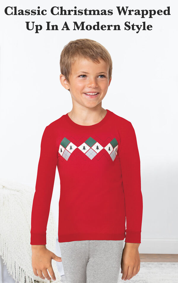 Boy standing by bed wearing Gray and Red Holiday Argyle Boy's Pajamas with the following copy: Classic Christmas wrapped up in a modern style image number 2