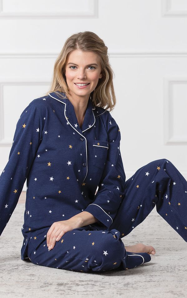 Model sitting down wearing Starry Night Boyfriend Pajamas; Navy blue button up pajamas with yellow and white star allover print image number 3