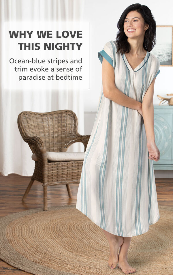 Model by chair wearing Margaritaville Cabana Striped Nighty - Blue/White with the following copy: Ocean-blue stripes and trim evoke a sense of paradise at bedtime image number 2
