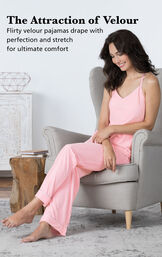Model sitting in chair wearing Velour Cami Pajamas - Pink with the following copy: The Attraction of Velour. Flirty velour pajamas drape with perfection and stretch for ultimate comfort. image number 2