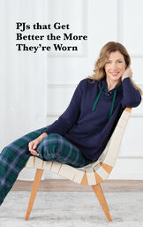 Model sitting on chair wearing Heritage Plaid Hooded Women's Pajamas with the following copy: PJs that get better the more they're worn image number 2