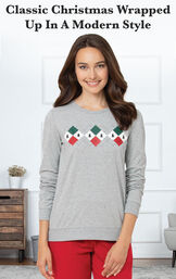 Model standing by couch wearing Gray and Red Holiday Argyle Women's Pajamas with the following copy: Classic Christmas wrapped up in a modern style image number 2