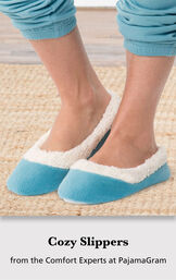 Model wearing Teal World's Softest Slippers standing on a rug with the following copy: Cozy Slippers from the Comfort Experts at PajamaGram image number 2