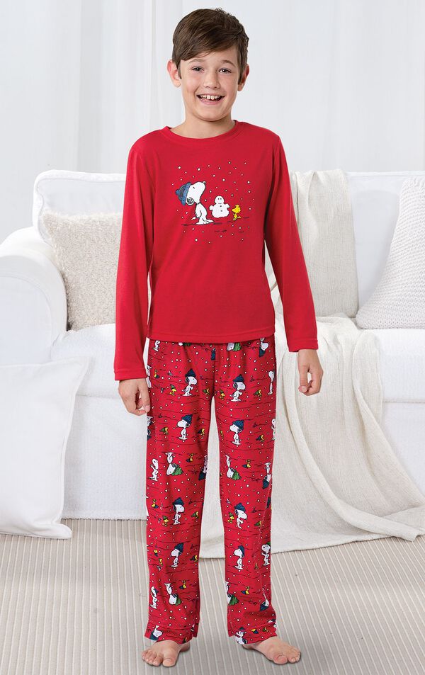 Model standing by couch wearing Red Snoopy and Woodstock Boys' Pajamas image number 1