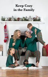 Family sitting by fireplace wearing matching Red and Green Christmas Tree Plaid Family Pajamas with the following copy: Keep Cozy in the Family image number 1