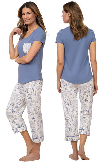 Model wearing Blue and White Seashell PJs for Women with Pocket Short-Sleeve Tee and matching Capris, facing away from the camera and then facing to the side