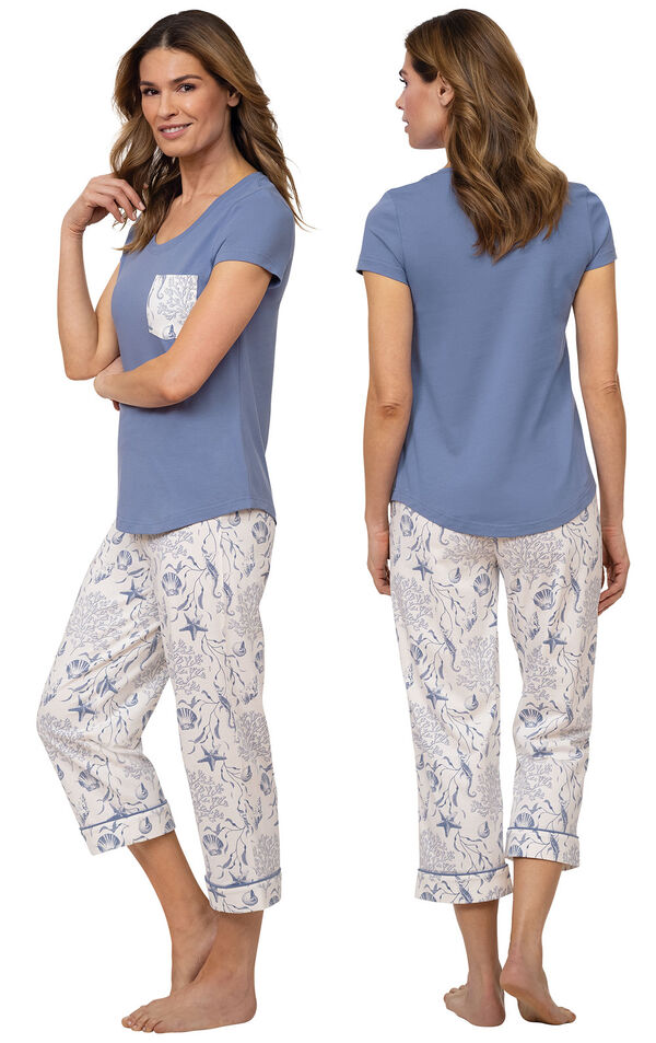 Model wearing Blue and White Seashell PJs for Women with Pocket Short-Sleeve Tee and matching Capris, facing away from the camera and then facing to the side image number 1