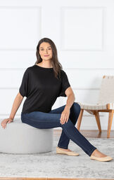 Model sitting on ottoman wearing Skinny Indigo Wash PajamaJeans paired with a Black top image number 2
