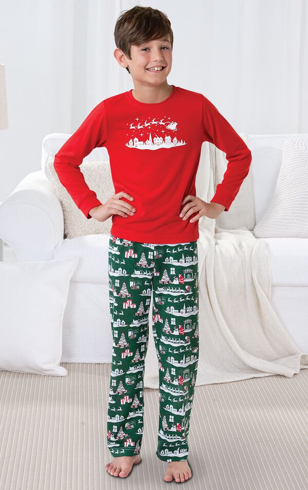 Boy standing by couch wearing Red and Green The Night Before Christmas Boys' Pajamas image number 1