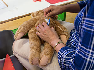 An image of a worker sewing a Vermont Teddy Bear