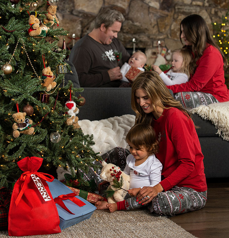 A family gathered around a Christmas tree wearing Pajamagram Nordic Matching Family Pajamas